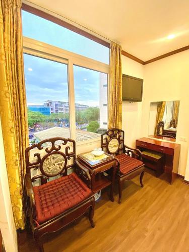 a living room with two chairs and a large window at Hanoi Asia 2 Long Bien in Hanoi