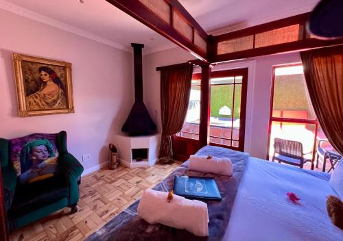 a bedroom with a bed and a chair and a fireplace at Goblin's Creek in St Helena Bay