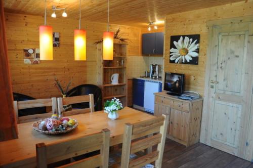 uma cozinha e sala de jantar com uma mesa de madeira e cadeiras em Ferienhaus 4 Personen FH7 