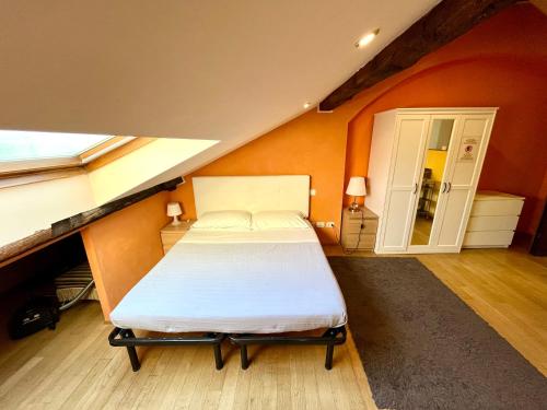 Bett in einem Zimmer mit orangefarbener Wand in der Unterkunft Il Nido 14 in Mailand
