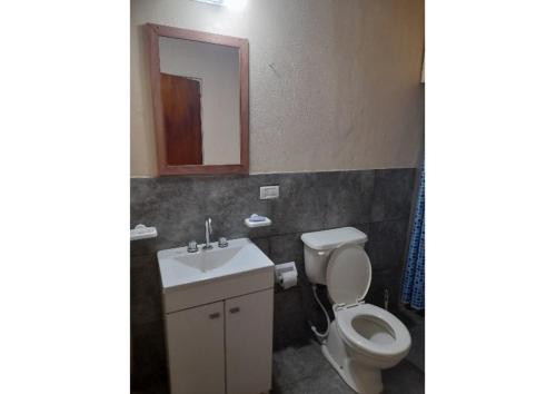 y baño con aseo, lavabo y espejo. en Maxidepartamento en Miramar