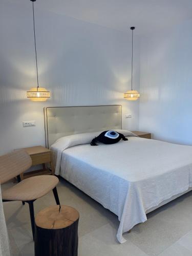 a bedroom with a bed and a chair and lights at Esperides in Platis Yialos Mykonos
