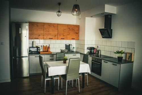 a kitchen with a table and chairs in it at Apartament mieszkanie dostęp zdalny bez potrzeby odbioru kluczy in Giżycko