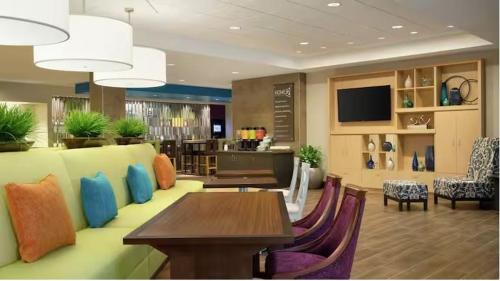 a living room with a couch and a table and chairs at Home2 Suites By Hilton Falls Church in Falls Church