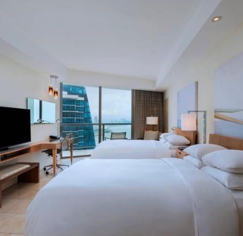 um quarto de hotel com duas camas e uma televisão de ecrã plano em JW MARRIOT em Cidade do Panamá