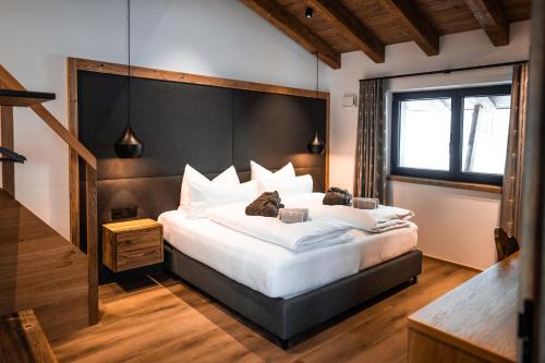 a bedroom with a large bed with a black headboard at Kellnergut Luxus-Chalet "FRIEDA" in Mühlbach am Hochkönig
