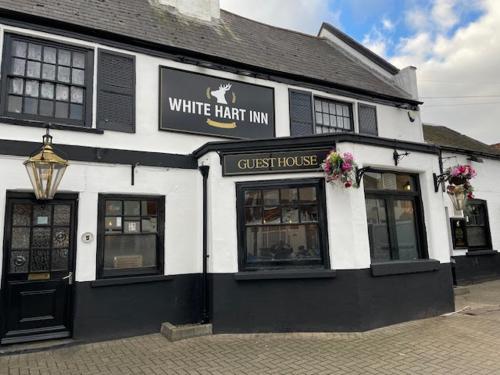 a white heat inn with a sign on the front of it at The White Hart Inn in Twickenham