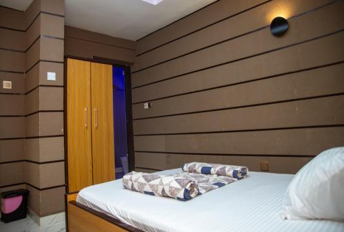 a bedroom with a bed and a wooden wall at Haffy Executive Hotels and Suite in Uyo