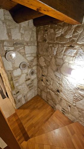 een zolderkamer met een stenen muur en houten vloeren bij Olive Garden's Paradise Villa in Skarinou