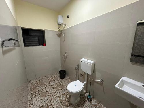 a bathroom with a toilet and a sink at Nosso Amor Stay in Siolim