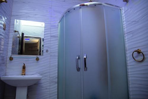 a bathroom with a shower and a sink at Haffy Executive Hotels and Suite in Uyo