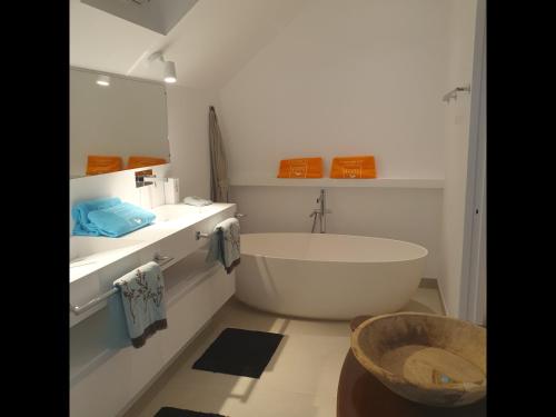 Baño blanco con bañera y lavamanos en Le Rocher Vert - Duplex climatisé pour 4, en Saint Barthelemy