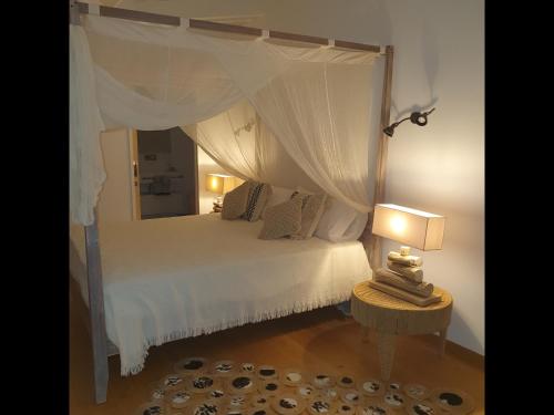 um quarto com uma cama de dossel branca em Le Rocher Vert - Duplex climatisé pour 4 em Saint Barthelemy