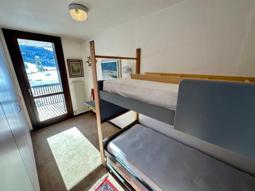 a bedroom with a bunk bed and a balcony at Bilocale Rio Falzè - Serafini in Madonna di Campiglio