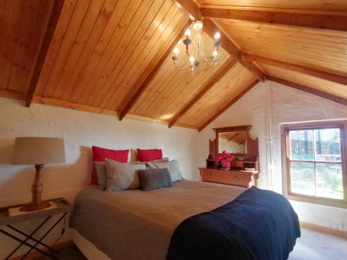 um quarto com uma cama num quarto com tectos em madeira em Amper Bo Farmstead em Sedgefield