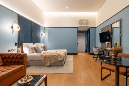 a hotel room with a bed and a couch at The Editory Riverside Hotel, an Historic Hotel in Lisbon
