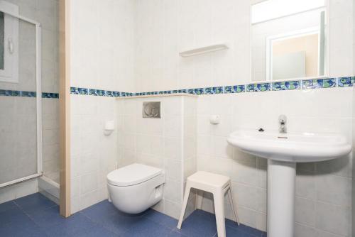a white bathroom with a toilet and a sink at Apartamentos Blanes-Condal Costa Brava in Blanes
