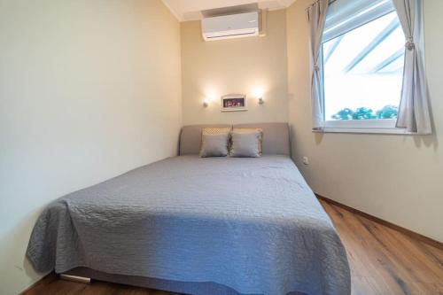 a bedroom with a bed with a blue comforter and a window at ABG House Pest in Budapest