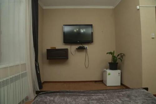 a bedroom with a flat screen tv on the wall at VIP Mini Hotel in Semey