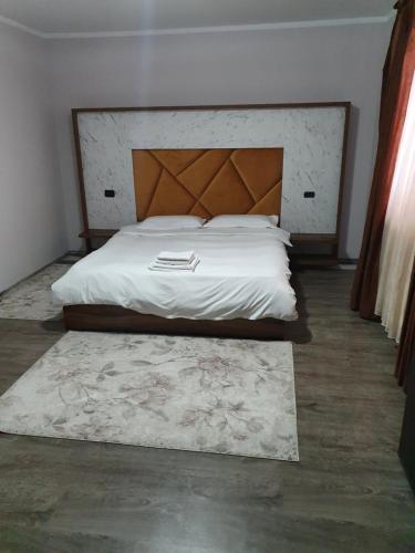 a bedroom with a large bed with a wooden headboard at CASA LAURENTIU in Borşa