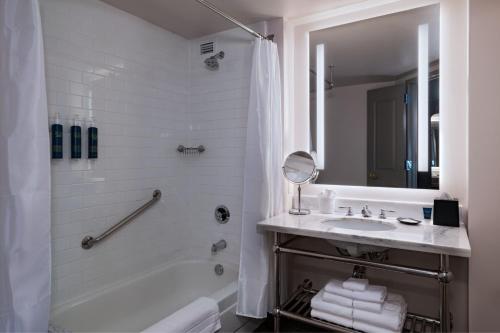 a white bathroom with a tub and a sink at Four Points by Sheraton Houston West in Houston