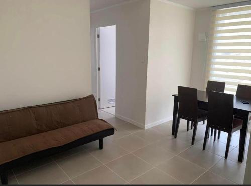 ein Wohnzimmer mit einem Sofa und einem Tisch mit Stühlen in der Unterkunft Departamento Serena , La Florida in La Serena