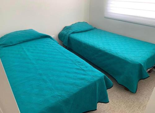 two beds sitting next to each other in a bedroom at Departamento Serena , La Florida in La Serena