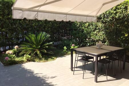 a table and chairs under an umbrella on a patio at Residence Apuamare in Pietrasanta