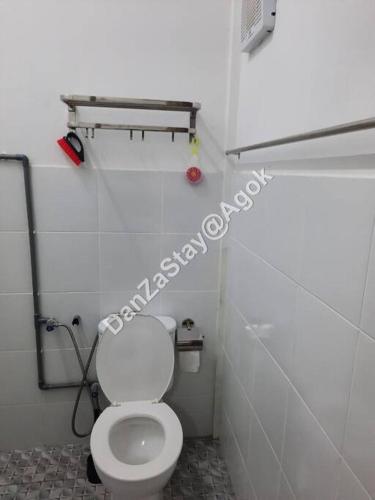 a bathroom with a white toilet in a stall at DanZaStay@Agok - Near Thai Border in Padang Besar