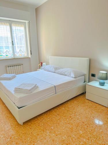 een slaapkamer met een groot wit bed en een raam bij La casita A&B in La Spezia