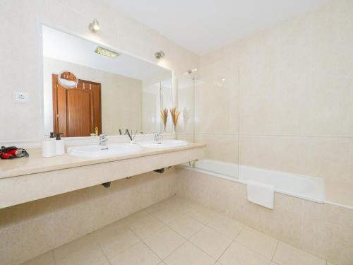 un bagno con 2 lavandini, uno specchio e una vasca di Cubo's Apartment Alhaurin Golf & Parking ad Alhaurín el Grande