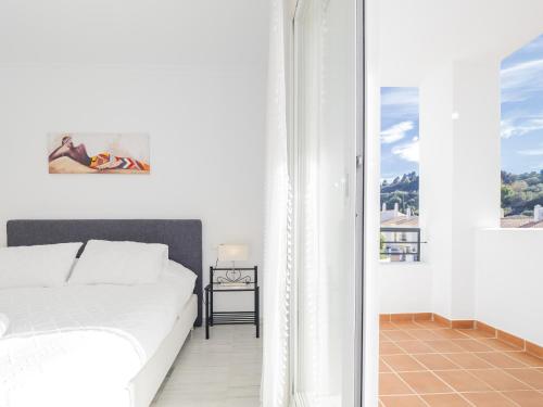 ein weißes Schlafzimmer mit einem Bett und einem Fenster in der Unterkunft Cubo's Apartment Alhaurin Golf & Parking in Alhaurín el Grande
