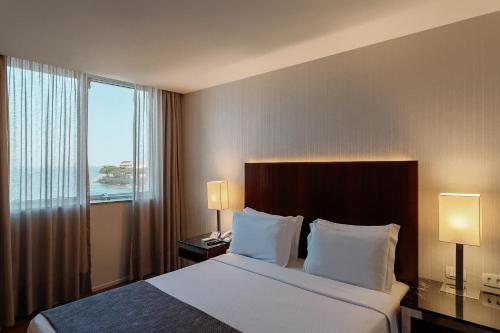 a hotel room with a bed and a large window at Orla Copacabana Hotel in Rio de Janeiro