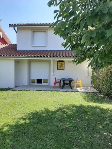 a house with a table and chairs in the yard at Gîte l'Etape in Pirajoux