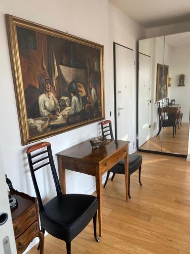 una habitación con una mesa y una pintura en la pared en Suite Del Parco, en Monza