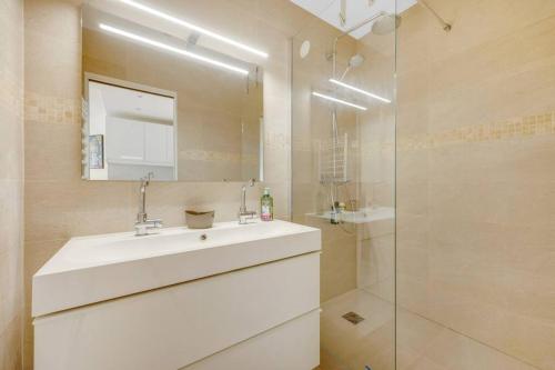 ein weißes Bad mit einem Waschbecken und einer Dusche in der Unterkunft Espace Champerret - 1 Bedroom 4 people in Levallois-Perret