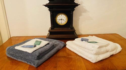 dos toallas y un reloj sentado en un suelo de madera en LINZ CITY CENTER - Historisches Apartment & Refugium en Linz
