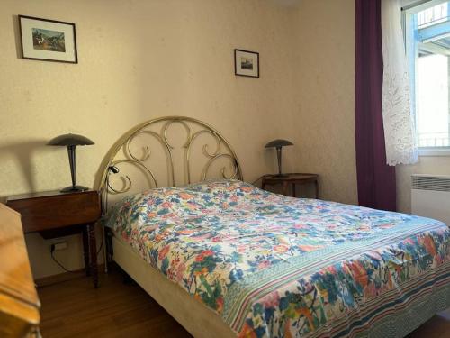 sypialnia z łóżkiem, 2 lampami i oknem w obiekcie Appartement T3 bord de la Vienne w mieście Chinon
