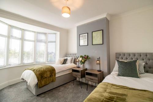 1 Schlafzimmer mit 2 Betten und einem Fenster in der Unterkunft K Suites - Carr Hill Road in Gateshead