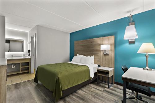 a hotel room with a bed and a desk at Quality Inn & Suites Vidalia in Vidalia