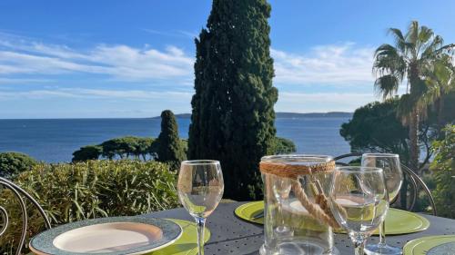 - une table avec des verres à vin et une vue sur l'océan dans l'établissement Clos de la Madrague, à Sainte-Maxime