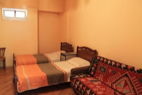 sala de estar con 2 camas y sofá en Hostel Old City Sololaki, en Tiflis