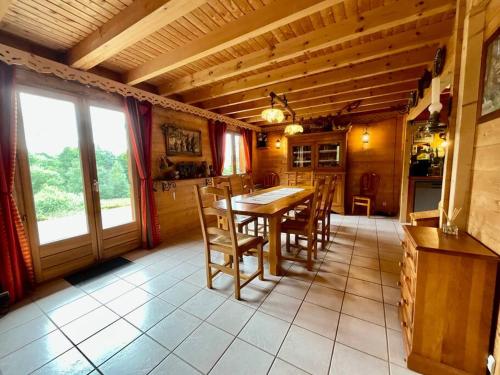 une salle à manger avec une table et des chaises en bois dans l'établissement Chalet Le Chappoix, 4* avec grand jardin, à Granges-sur-Vologne
