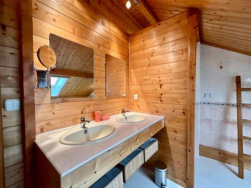 a bathroom with two sinks in a wooden wall at Chalet Le Chappoix, 4* avec grand jardin in Granges-sur-Vologne
