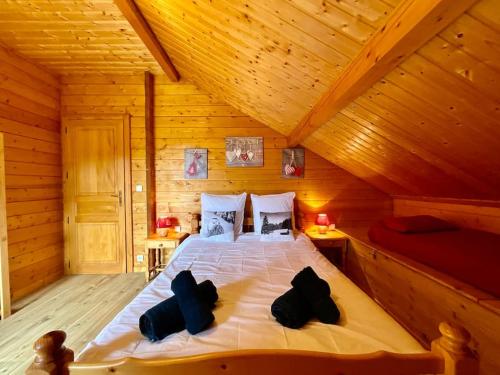 a bedroom with a bed in a wooden cabin at Chalet Le Chappoix, 4* avec grand jardin in Granges-sur-Vologne