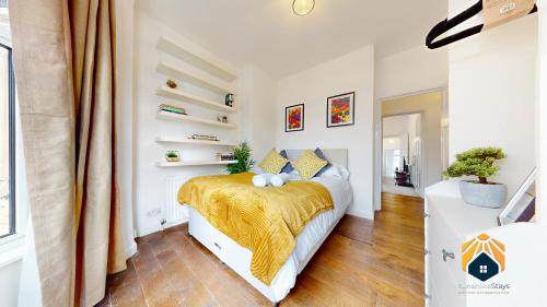 um quarto com uma cama com um cobertor amarelo em Spacious Cardiff 2-Bed Flat with Parking em Cardiff