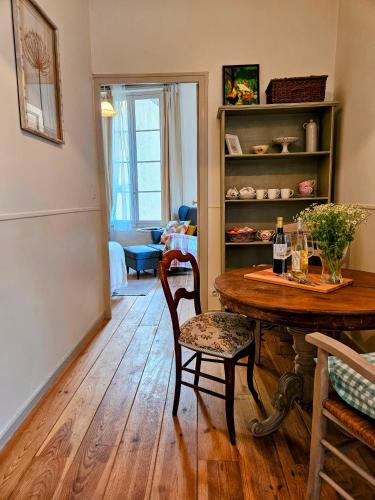 un salon avec une table et des chaises en bois dans l'établissement La Forge - Historical Apartment in Sarlat, à Sarlat-la-Canéda