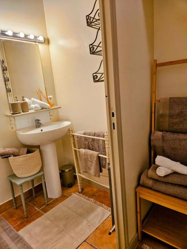 une salle de bain avec un lavabo, un miroir et des serviettes dans l'établissement La Forge - Historical Apartment in Sarlat, à Sarlat-la-Canéda