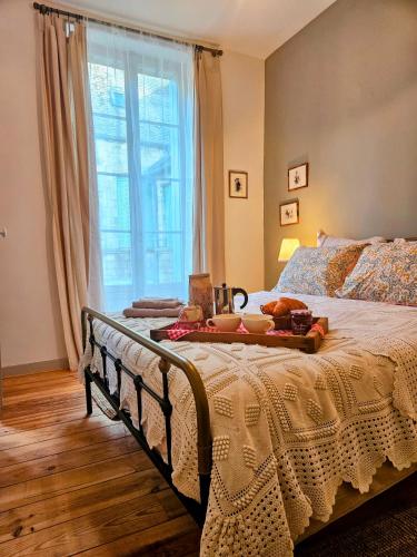 - une chambre avec un lit et un plateau de nourriture dans l'établissement La Forge - Historical Apartment in Sarlat, à Sarlat-la-Canéda