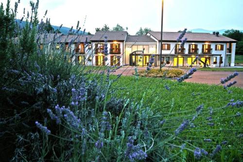 a building with a field of purple flowers in front of it at Hotel Canova Sport & Relax in Cavaso del Tomba